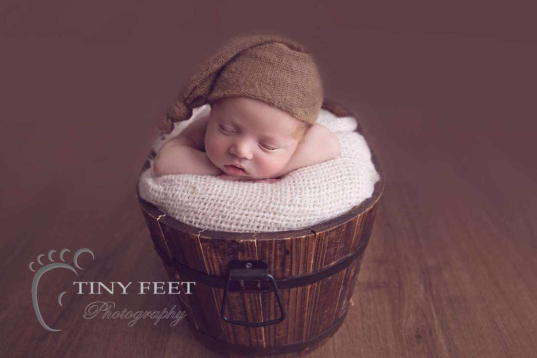 Tiny Feet Photography, newborn baby boy posed chin in hands in bucket