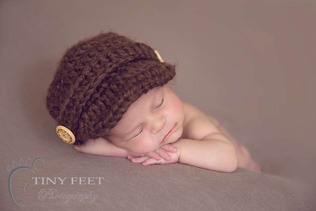 Tiny Feet Photography Newborn boy chin on hand pose on brown blanket