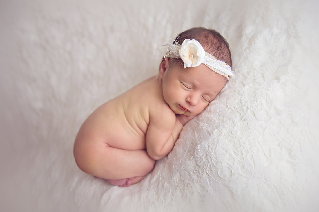 Tiny Feet Photography Newborn baby girl posed on lace blanket on beanbag