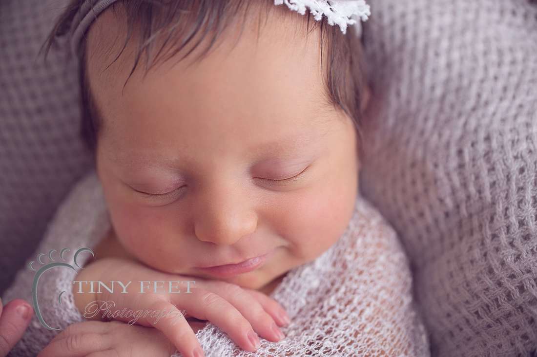 Tiny Feet Photography, close up shot of newborn baby girl in grey wrap in a bowl