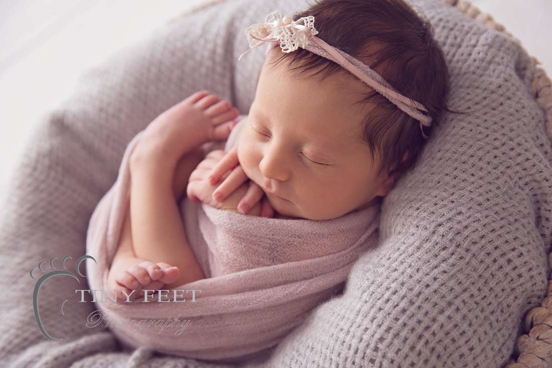 Tiny Feet Photography, newborn baby girl in pink wrap backlit in a bowl
