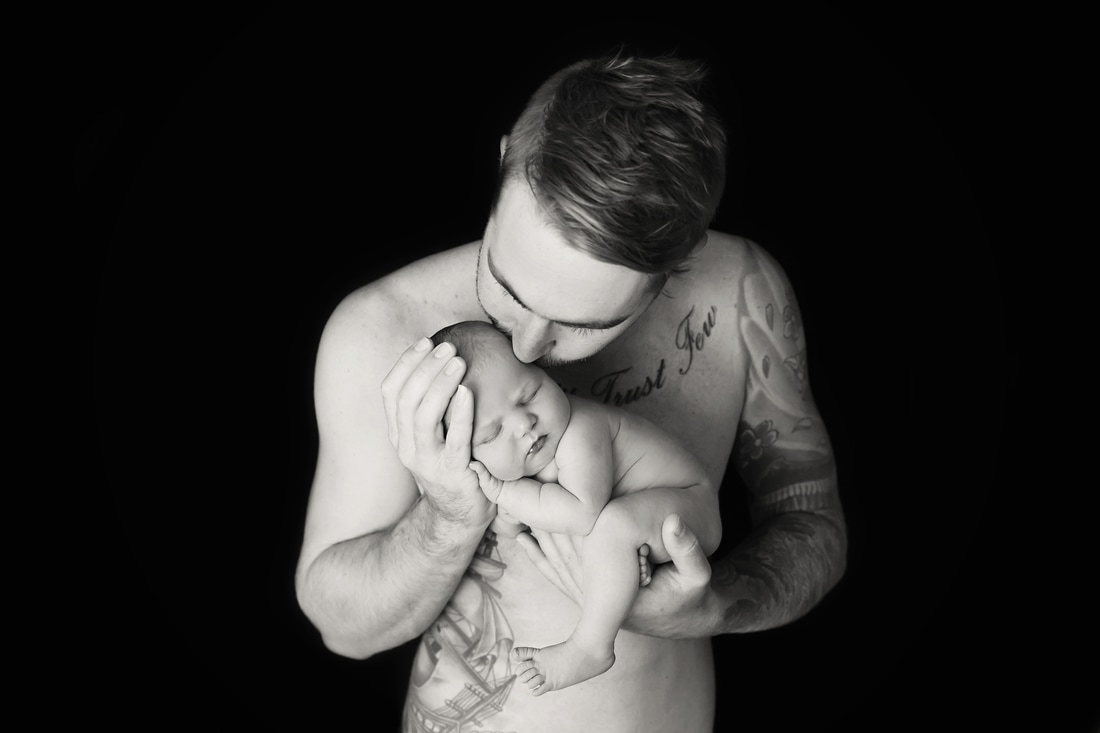 dad posing with newborn black and white