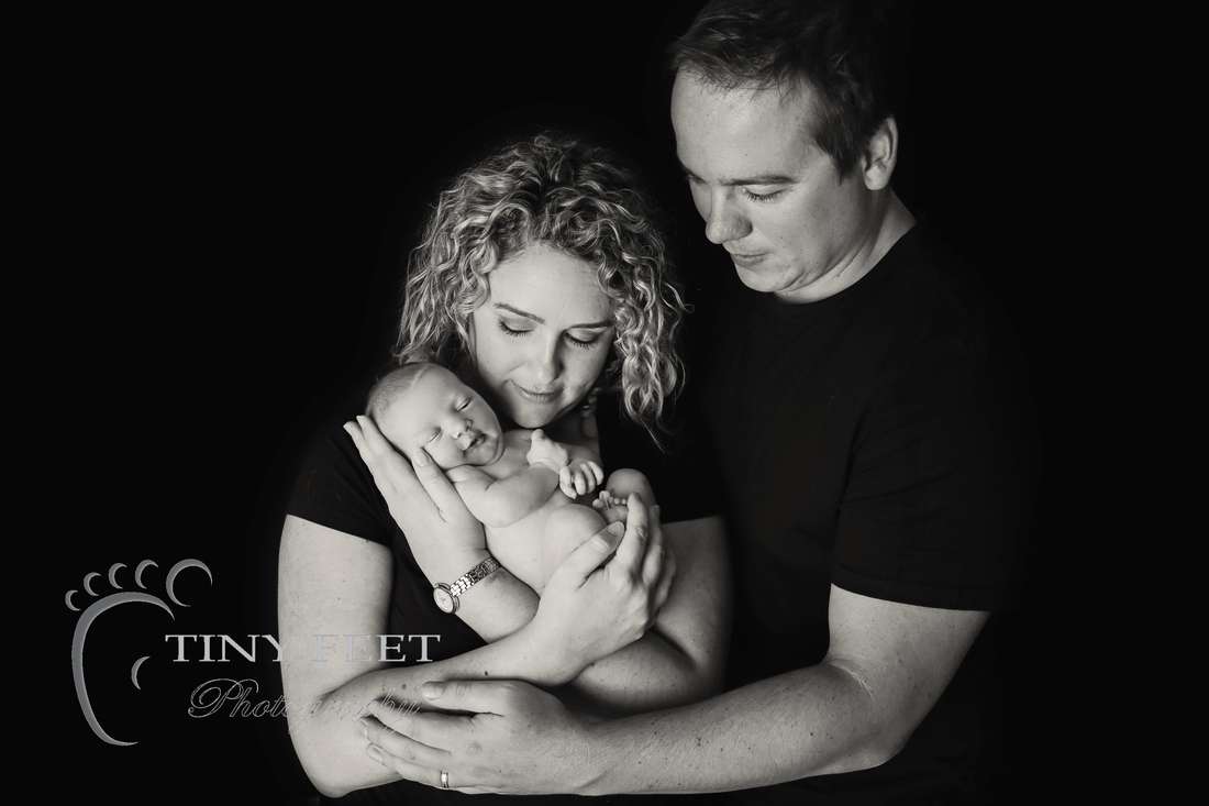 Tiny Feet Photography black and white image of newborn with parents