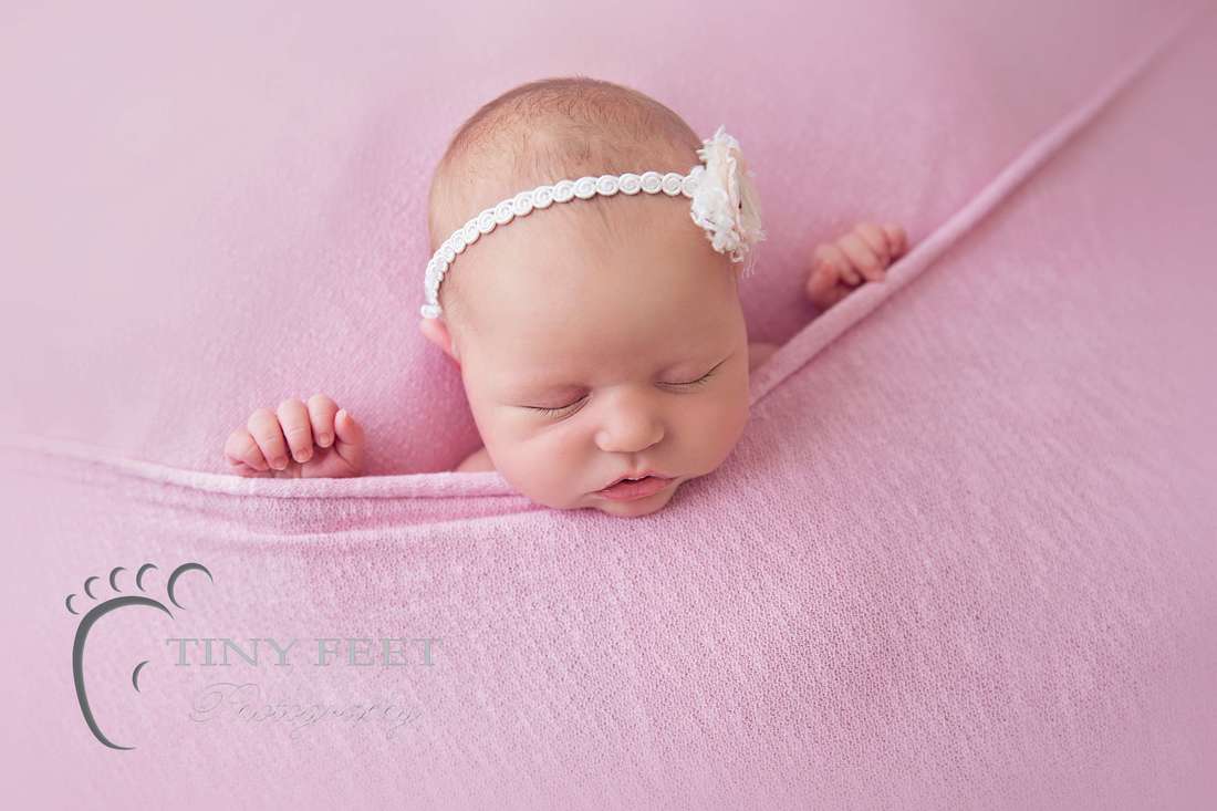 Tiny Feet Photography newborn baby girl tucked in to pink blanket