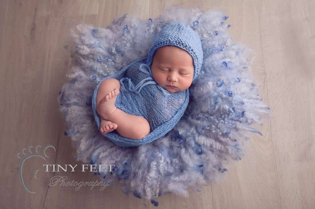 Tiny Feet Photography newborn baby boy in blue wrap with blue curly felt