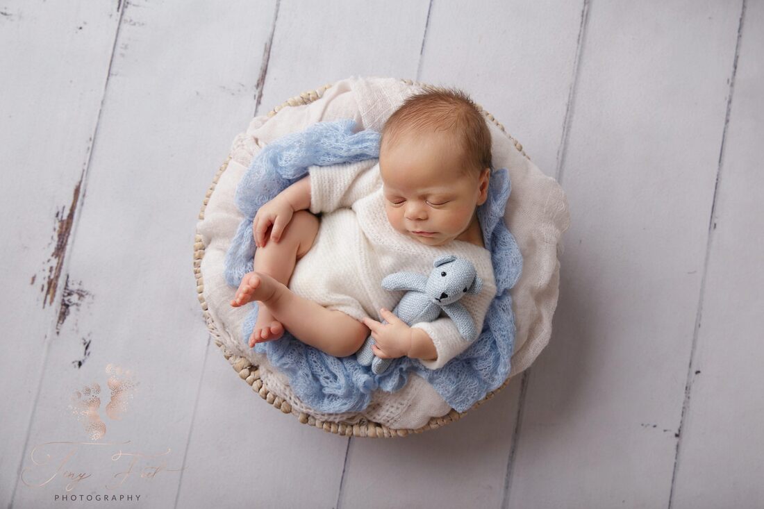 Tiny Feet Photography Newborn baby boy posed in white basket with blue fabric