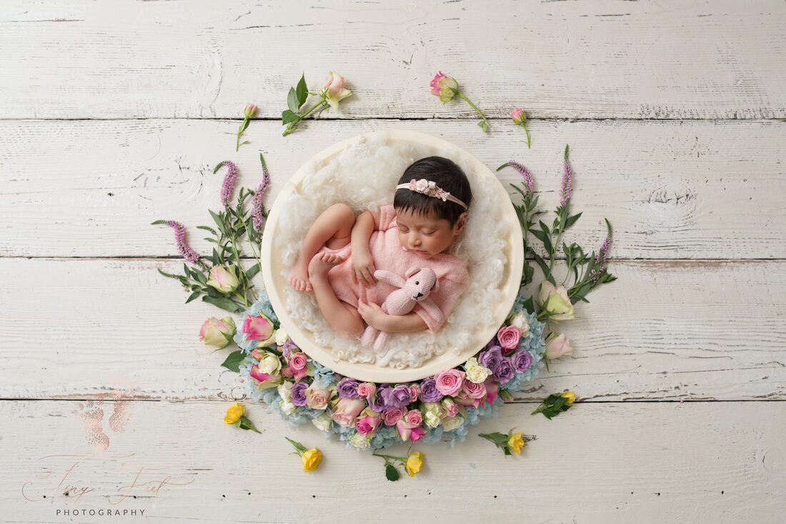 Tiny Feet Photography image of a sweet baby girl in white lace in a bowl surrounded by flowers and lace