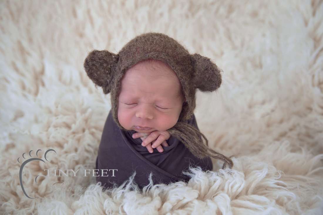Tiny Feet Photography Newborn baby boy in potato sack pose on white flokati