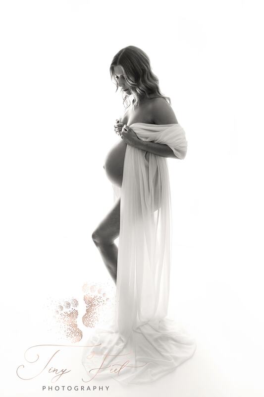 Tiny Feet Photography Black and white back lit studio maternity image of mum to be with white chiffon material