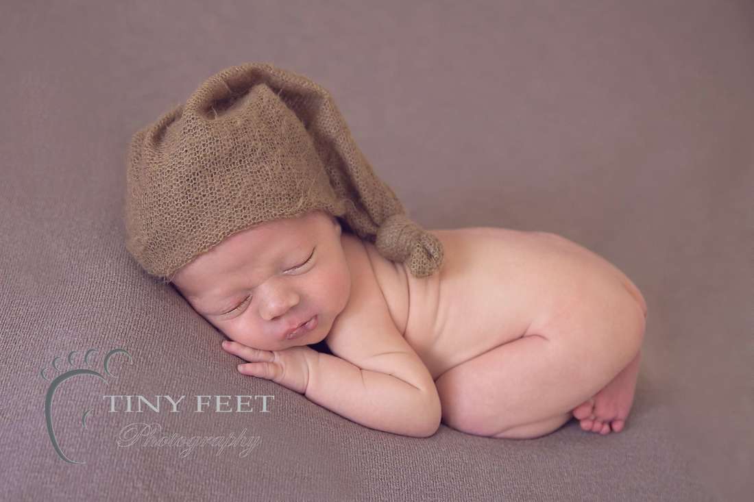 Tiny Feet Photography Newborn baby boy in bum up pose one brown beanbag backdrop