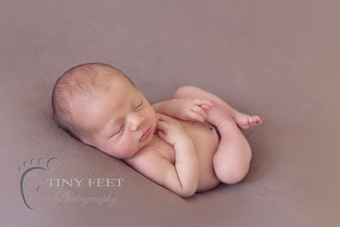 Tiny Feet Photography Newborn baby boy in huckfinn on brown beanbag