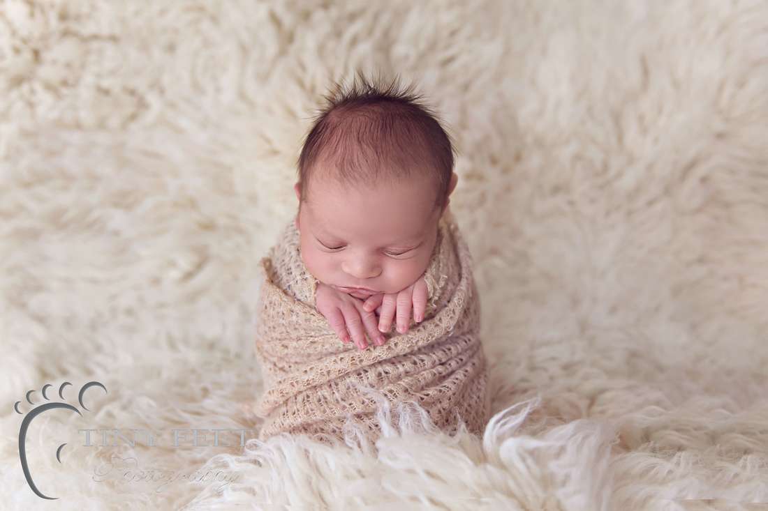 Tiny Feet Photography Newborn boy posed in potato sack pose on flokati