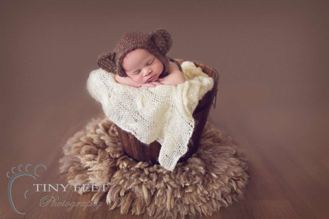 Tiny Feet Photography Newborn boy posed on belly in bucket