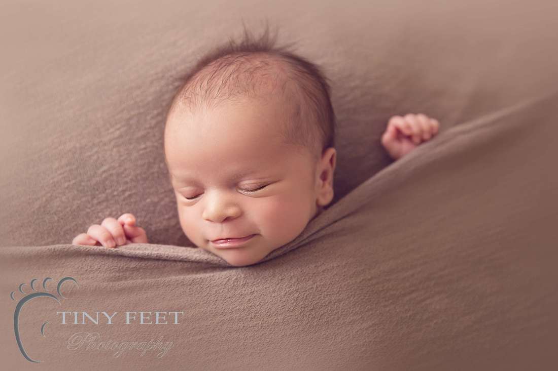Tiny Feet Photography Newborn boy tucked in pose on brown stretch blanket