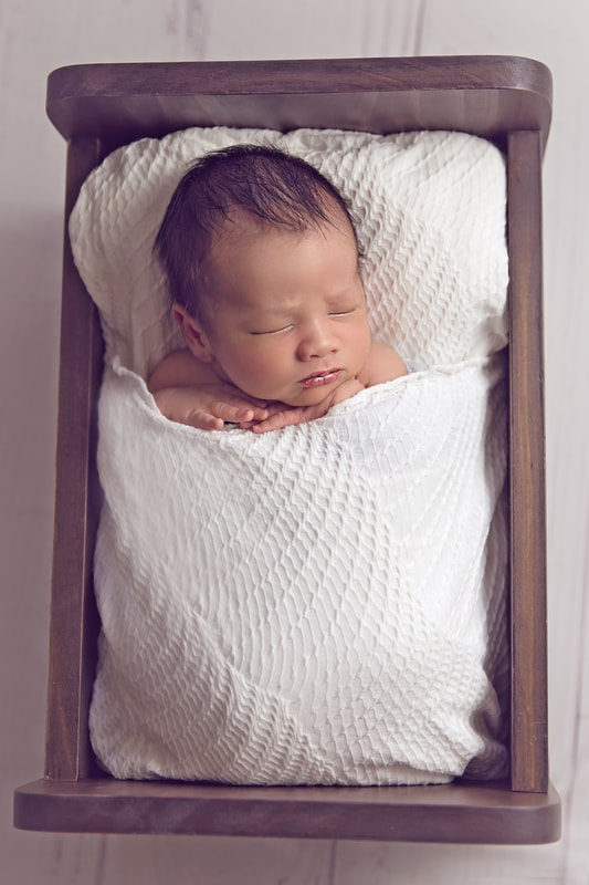 Tiny Feet Photography tucked in pose in newborn bed of baby boy