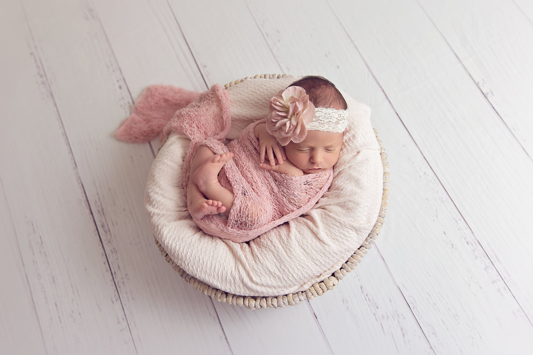 Tiny Feet Photography Newborn baby girl in pink wrap posed in basket