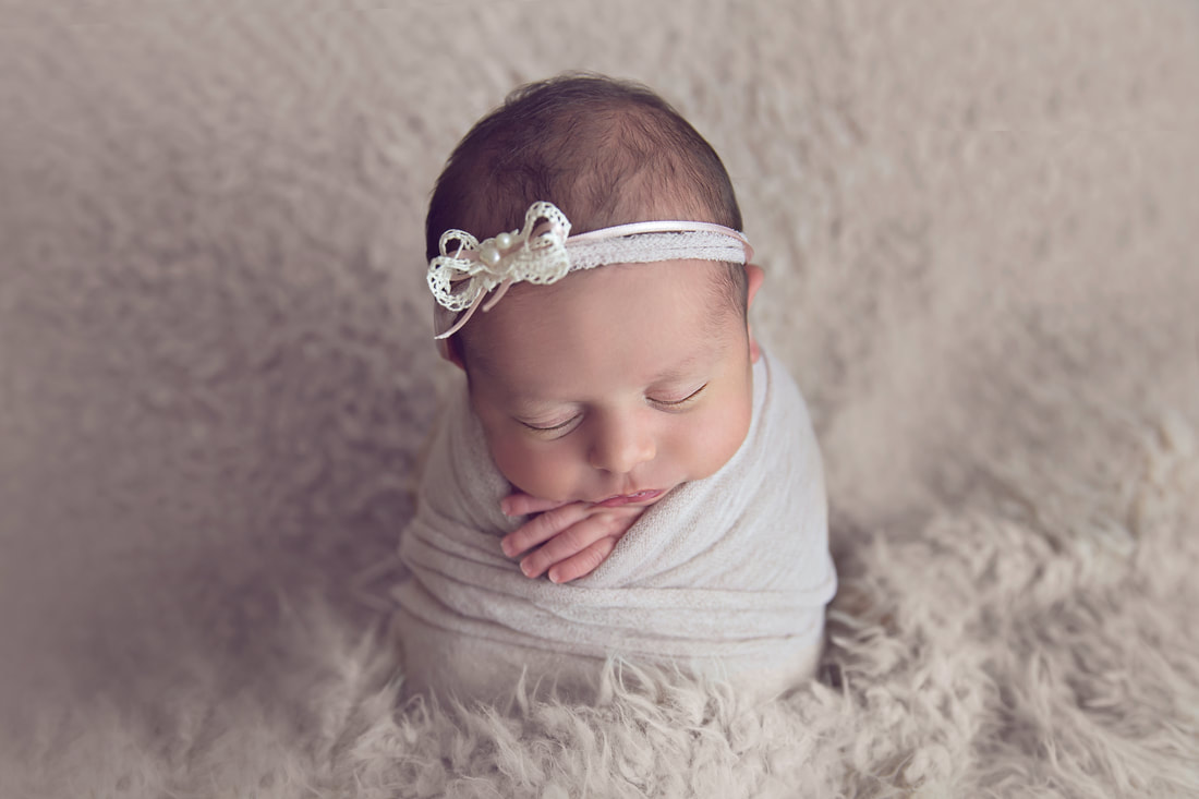 Tiny Feet Photography Newborn baby girl wrapped and posed in potato sack pose on flokati