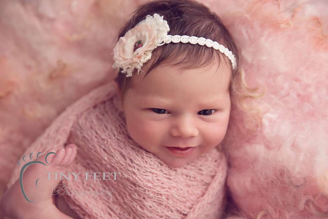 Tiny Feet Photography newborn baby girl in pink wrap with pink curly felt