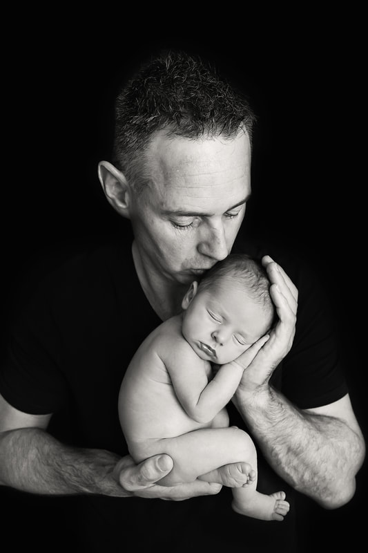 Tiny Feet Photography newborn posing with dad on black backdrop