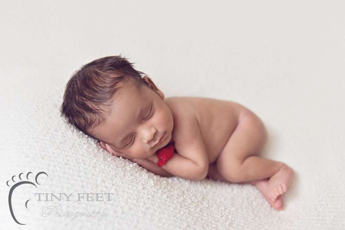 Tiny Feet Photography newborn baby boy posed in on side on cream blanket on beanbag