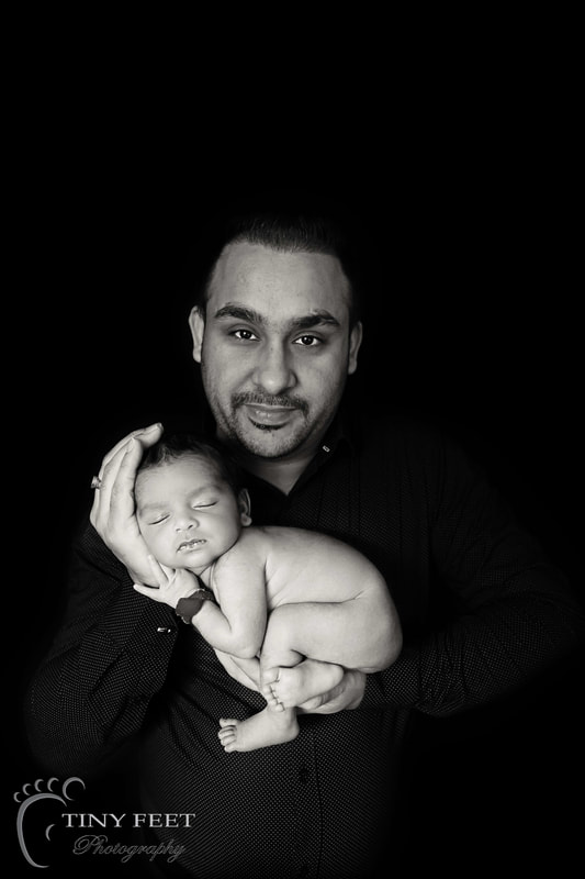 Tiny Feet Photography newborn baby posed with dad on black and white