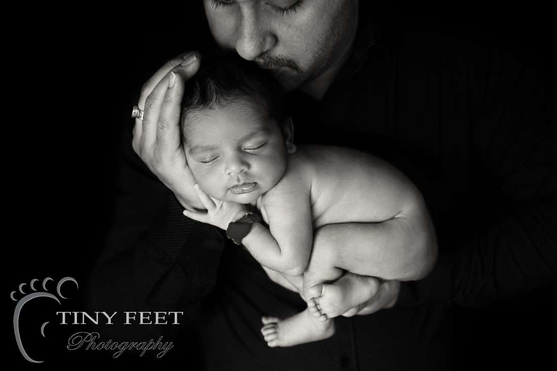 Tiny Feet Photography newborn baby posed in dads hands black and white