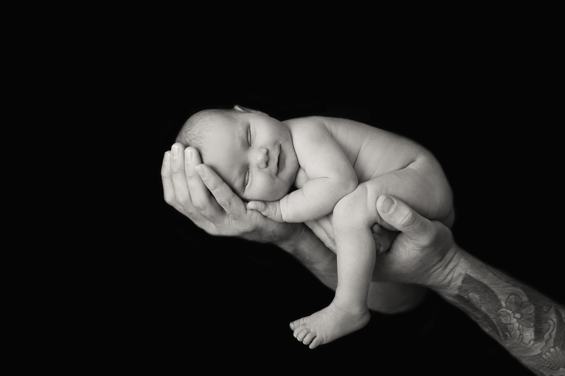 Tiny Feet Photography Newborn in dads hands with big smile