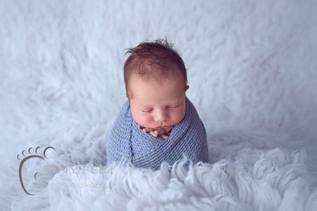 Tiny Feet Photography baby boy wrapped in blue wrap in potato sack on flokati