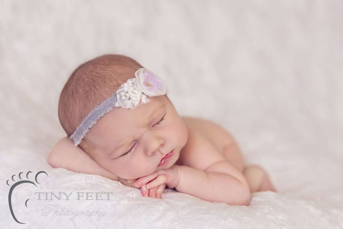 Tiny Feet Photography Newborn baby girl posed on lace blanket in chin on hand pose