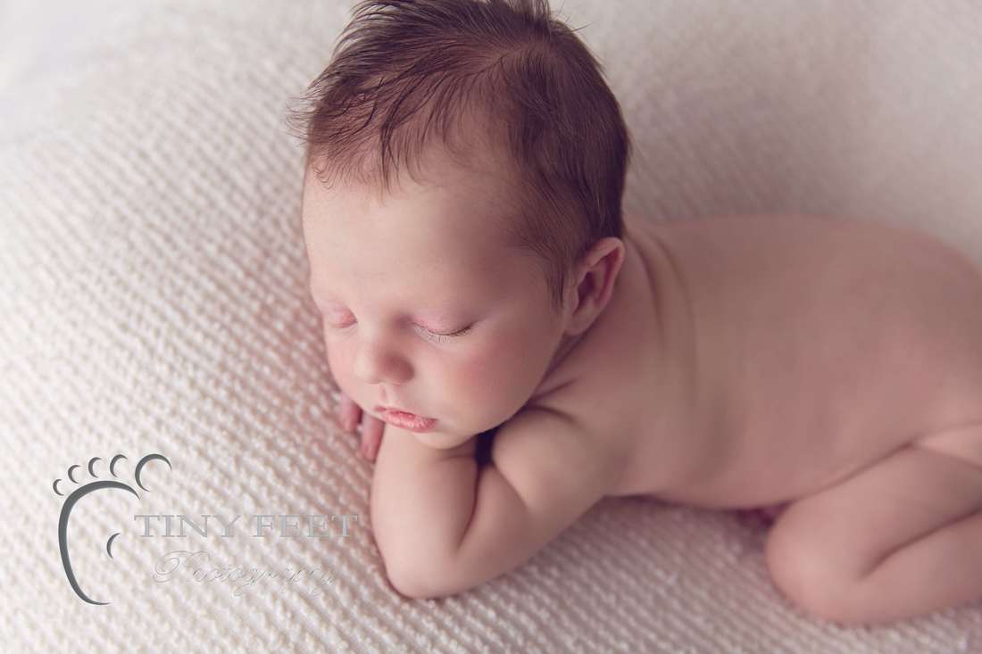 Tiny Feet Photography baby boy posed in chin on hand on cream blanket