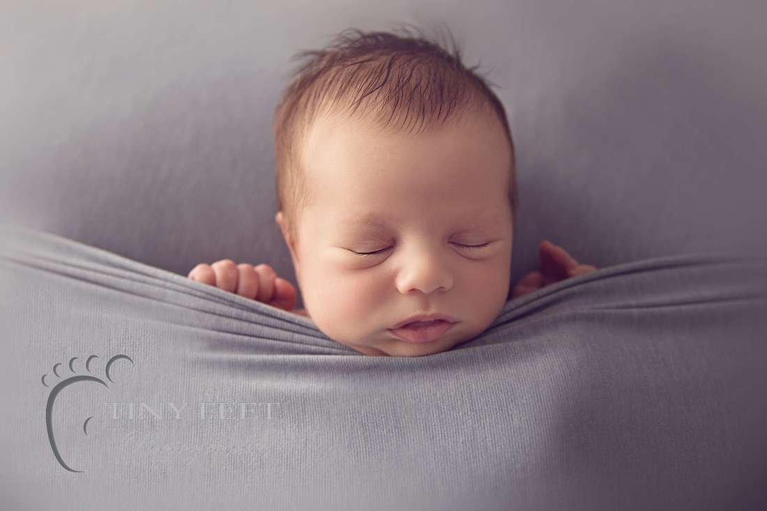 Tiny Feet Photography baby boy tucked in under grey blanket
