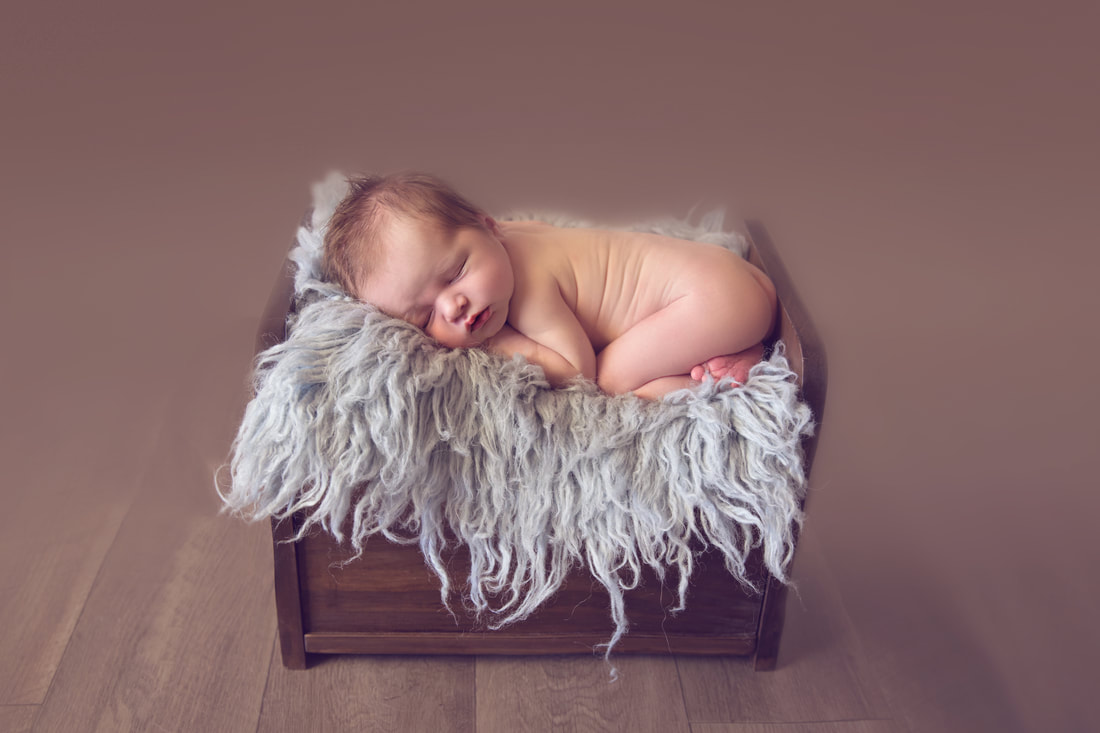 Tiny Feet Photography Newborn baby boy posed in bum up pose on wooden bed