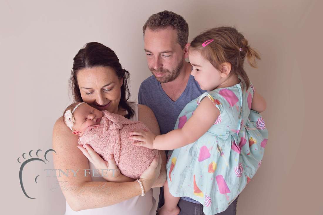 Tiny Feet Photography newborn baby girl posed with family