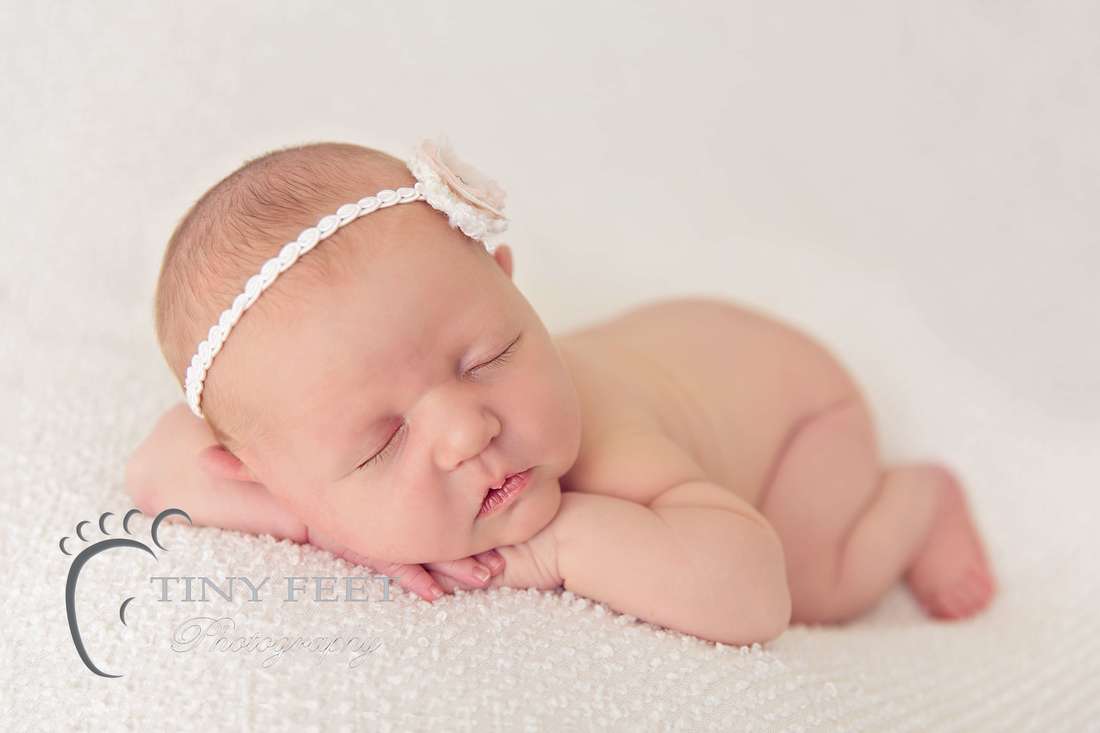 Tiny Feet Photography newborn baby girl posed on cream blanket on beanbag