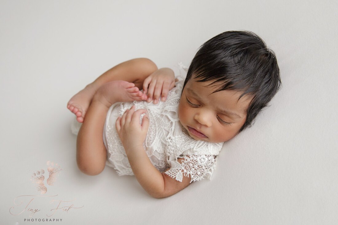 Tiny Feet Photography Newborn girl posed white white lace romper in cream