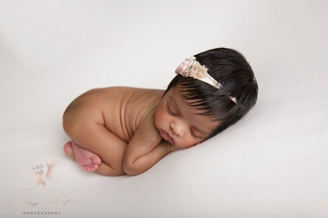 Tiny Feet Photography Newborn girl posed naked in bum up pose on cream blanket