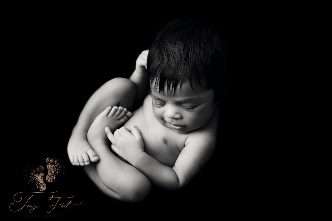 Tiny Feet Photography Newborn girl black and white smiling womb pose