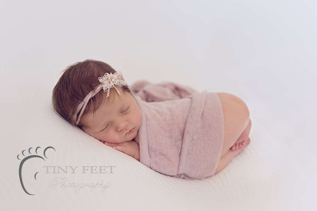 Tiny Feet Photography baby girl posed on white blanket on beanbag