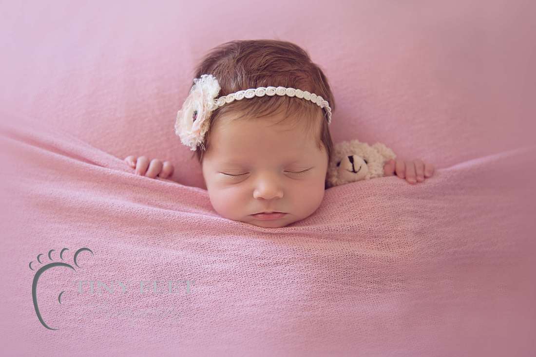 Tiny Feet Photography Newborn baby posed in tucked in on pink blanket