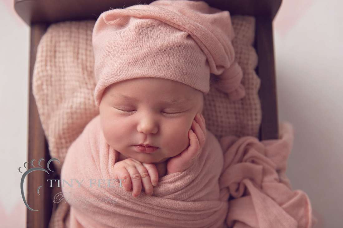 Tiny Feet Photography Perth newborn girl posed in Little Jar Big Dreams wooden bed in pink wrap