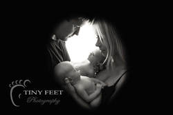 Tiny Feet Photography twin newborn boys posed with mum and dad back lit