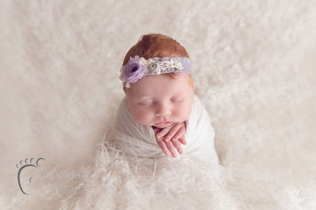 Tiny Feet Photography Newborn baby girl in potato sack pose on white flokati