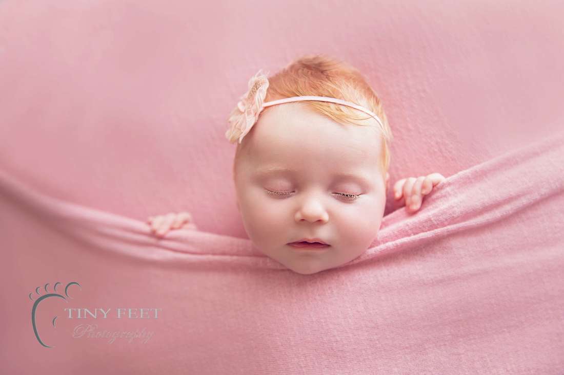 Tiny Feet Photography Newborn baby girl posed in tucked in pose in pink blanket