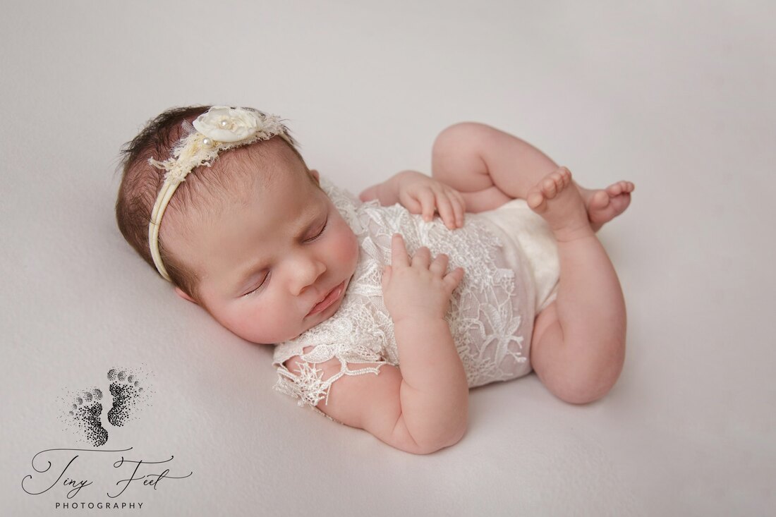 Tiny Feet Photography In home studio newborn session in huck finnpose on the beanbag with creams