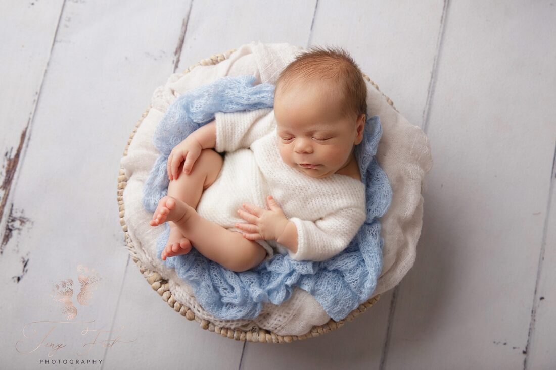 PictureTiny Feet Photography Newborn baby boy posed in white basket with blue fabric
