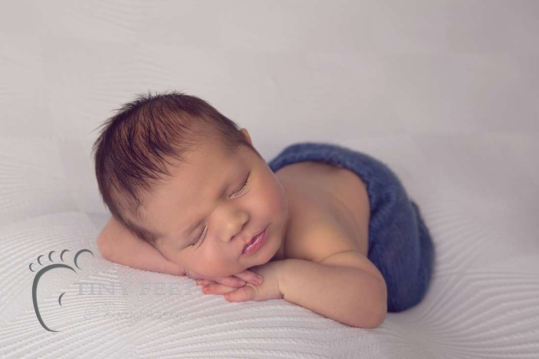 Tiny Feet Photography newborn baby boy posed on hands on white blanket