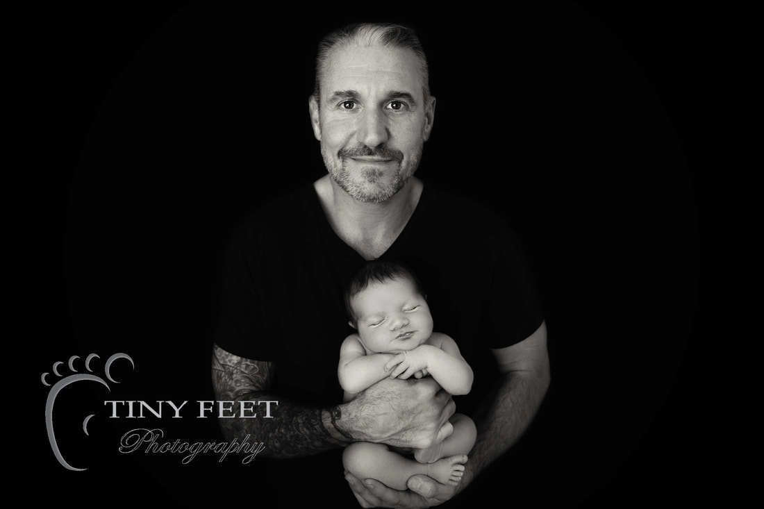Tiny Feet Photography black and white image of newborn baby boy posed with dad