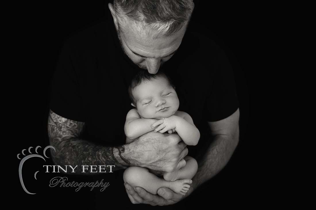 Tiny Feet Photography black and white image of newborn baby boy posed with dad