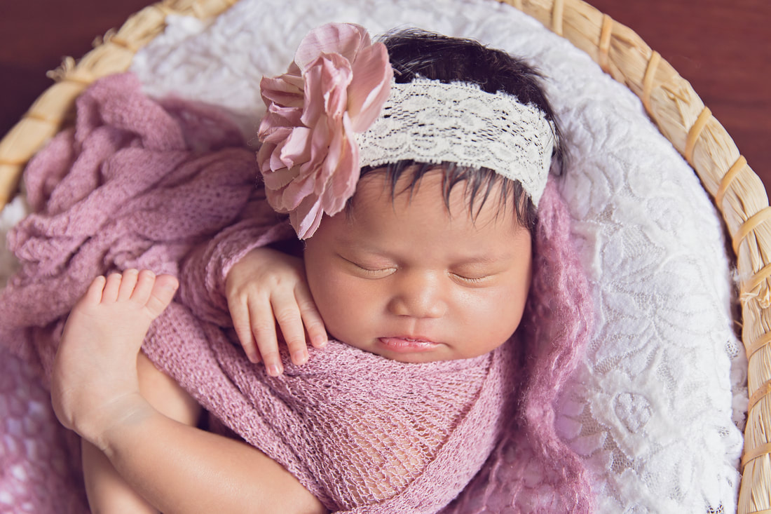 Newborn girl in pink in basket