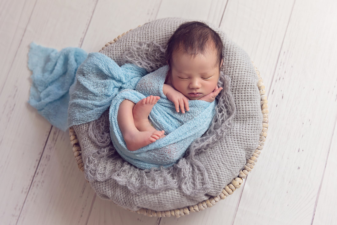 Tiny Feet Photography Newborn baby boy posed in grey basket